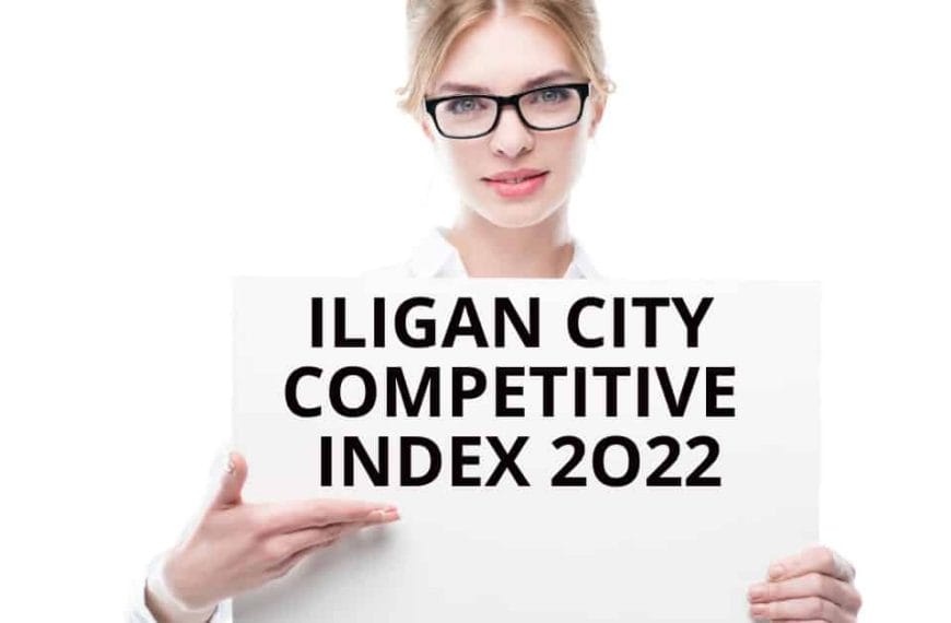 Person holding a sign that reads ILIGAN CITY COMPETITIVE INDEX 2022 against a white backdrop. #IliganCity.