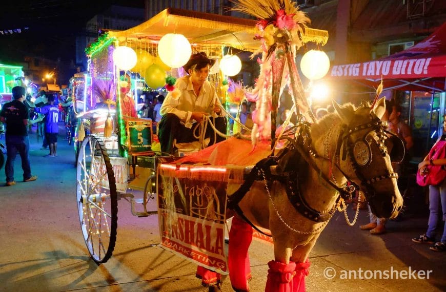 Horse-drawn carriage adorned with colorful lights and flowers dazzles in Iligan Citys vibrant nighttime parade.