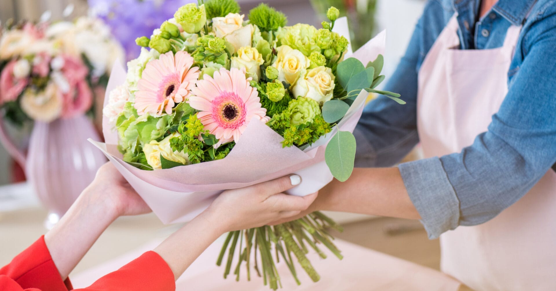 Ang mga kamay ay nagpapalitan ng isang palumpon ng mga rosas na rosas at dilaw na rosas, na nakabalot sa kulay-rosas na papel, na ginawa ng isang tindahan ng bulaklak sa Iligan.