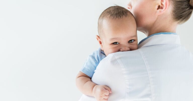 Adult holding a baby against their shoulder, baby looking at the camera, reminiscent of a serene moment in Pedia Iligan.