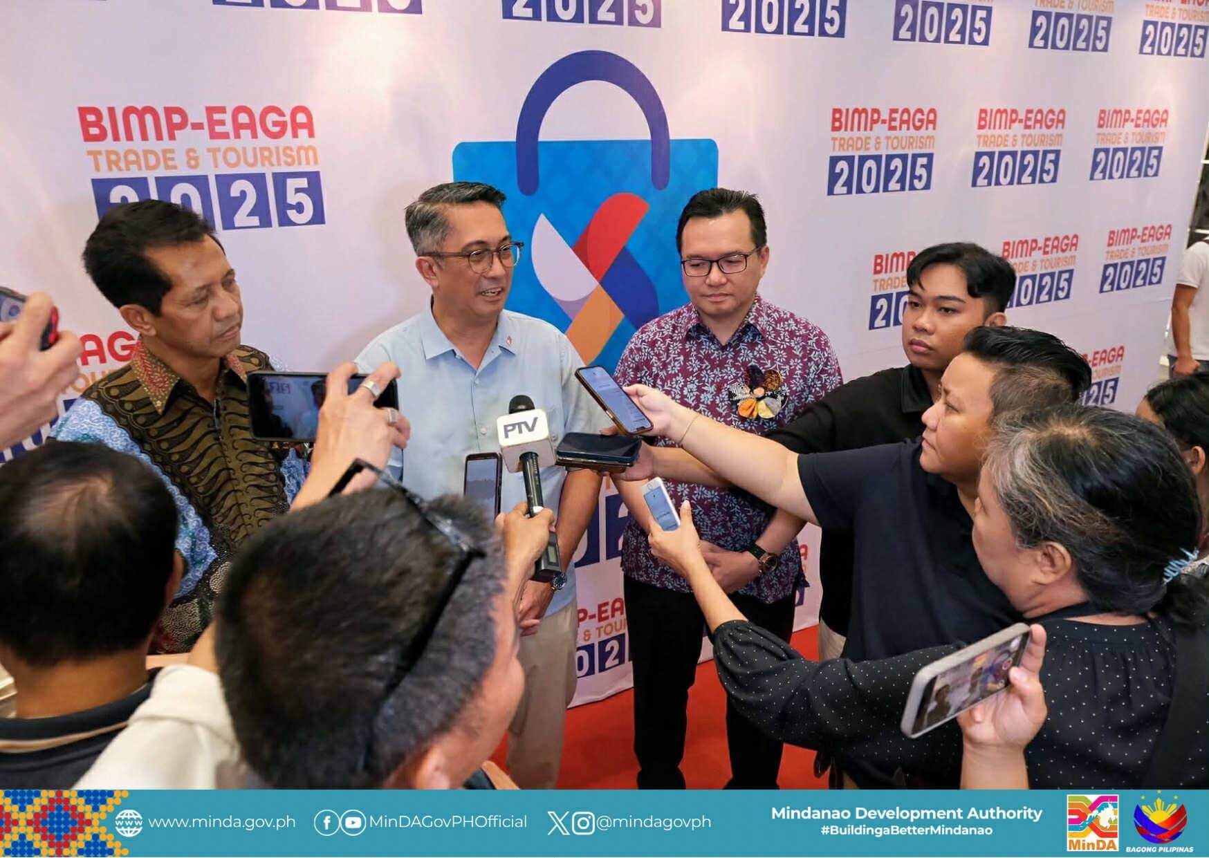a man speaks to reporters at a bimp eaga 2025 event, surrounded by media and microphones.