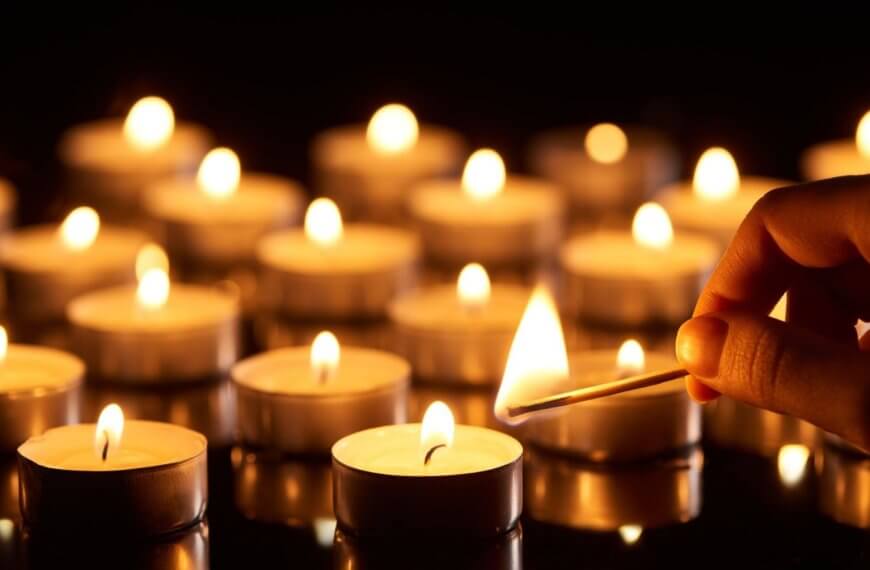 a hand lights a tealight candle with a match—symbolizing hope amid darkness and cho serbisyo.