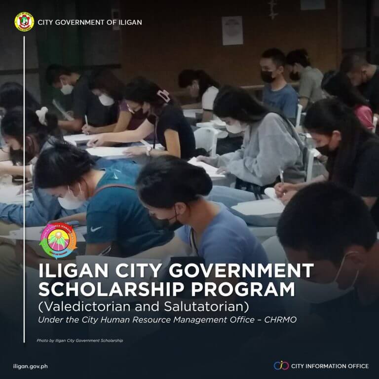 top students wearing masks sit at desks, writing, during the city scholarship program exam in iligan.