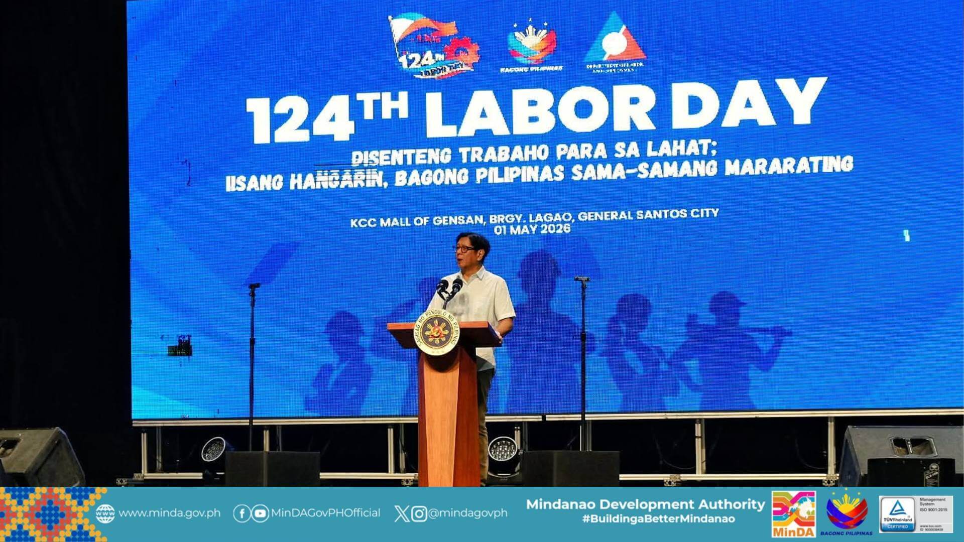 PBBM speaks at a podium before a large blue “124th mindanao labor day” event backdrop in general santos city.